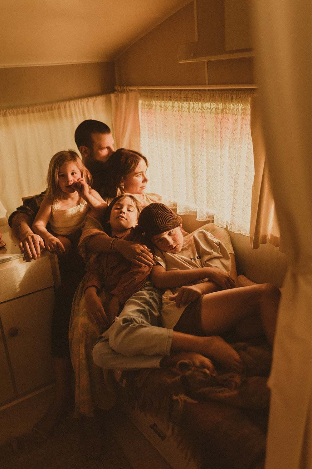 Sydney-family-photography-family-of-five-share-cuddle-in-nook-of-vintage-caravan