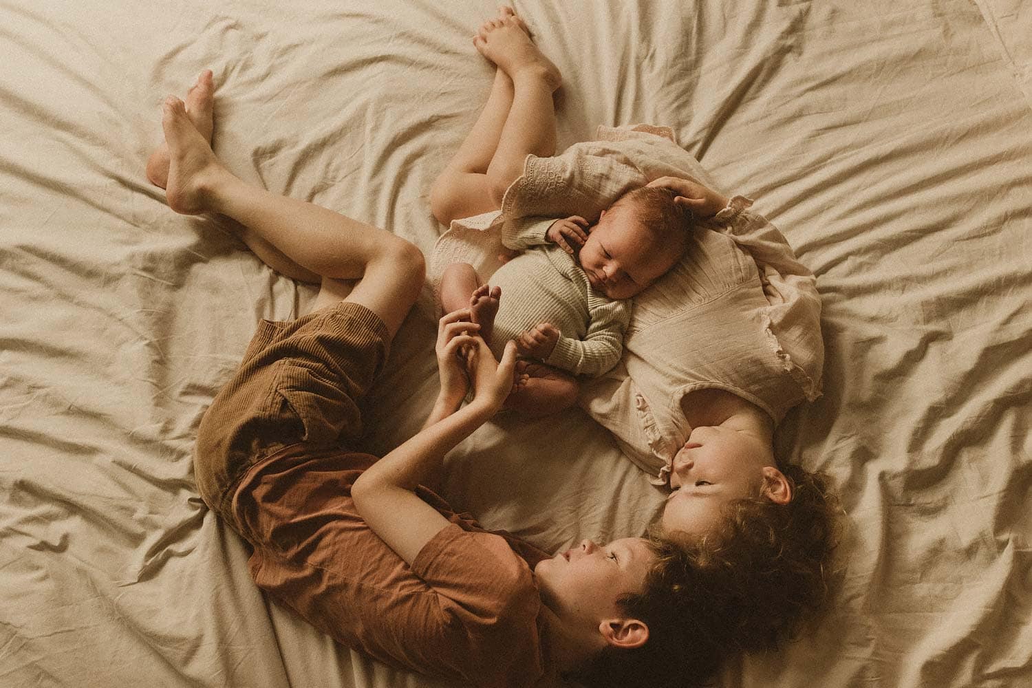 Sydney-newborn-photographer-kids-with-their-newborn-baby-brother-cuddling