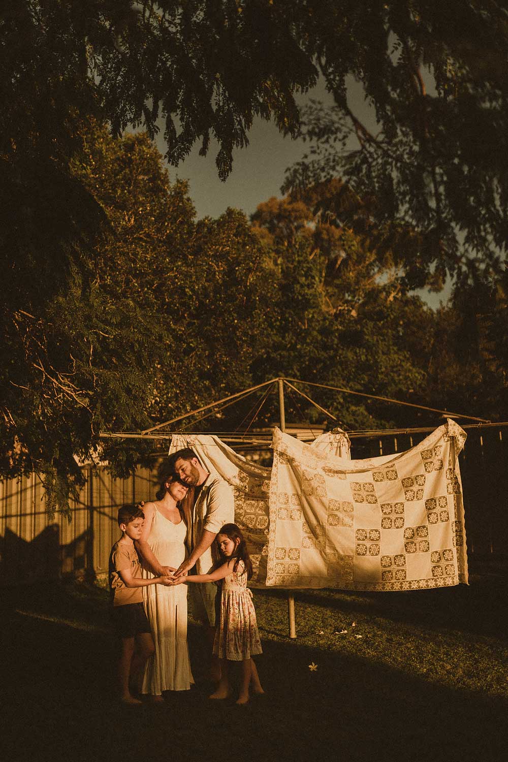 Backyard maternity photos by the clothes line. family cuddling. Sydney