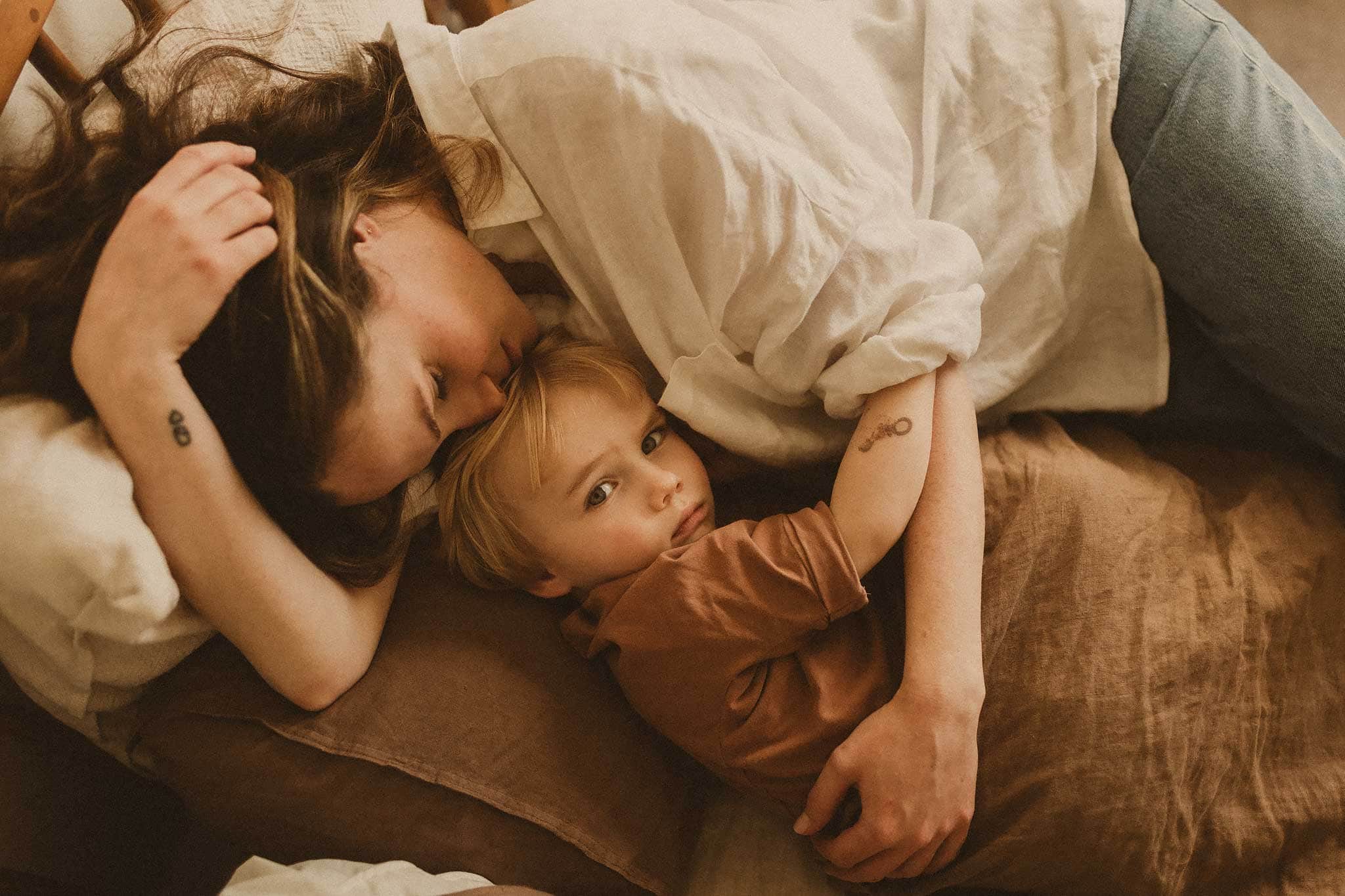 Mum-snuggling-into-shy-toddler-during-their-in-home-family-shoot-sydney